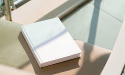 book cover mockup design. blank book template on soft beige armchair on terrace or balcony , shadow overlay