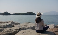 Woman sit on seaside and look at the scenery view